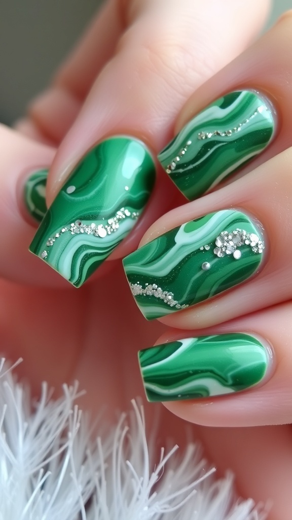 Close-up of green marble nail art with white accents and glitter, perfect for Christmas.